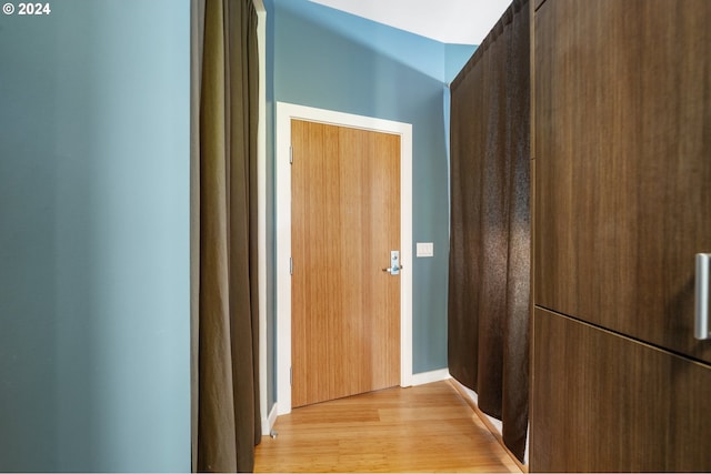 corridor with light hardwood / wood-style flooring