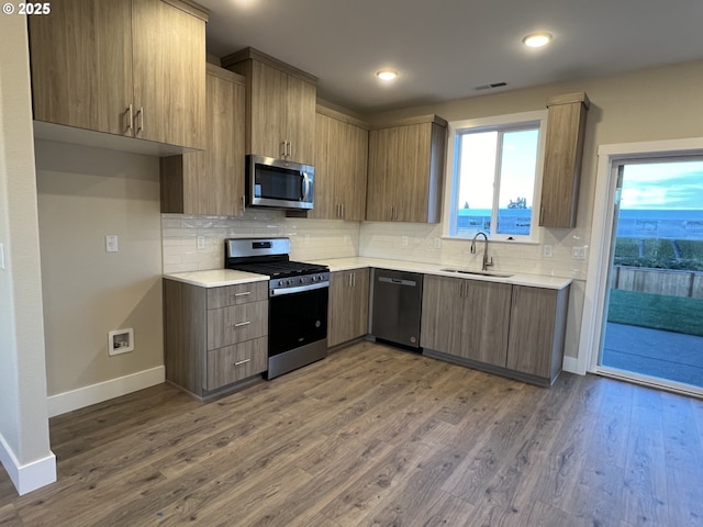 kitchen with stainless steel appliances, dark hardwood / wood-style floors, sink, and decorative backsplash