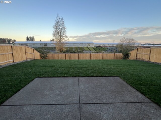 yard at dusk featuring a patio