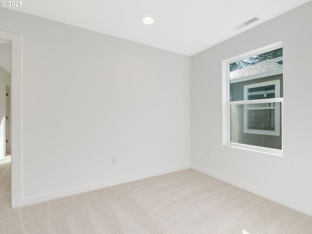 carpeted spare room featuring recessed lighting, visible vents, and baseboards