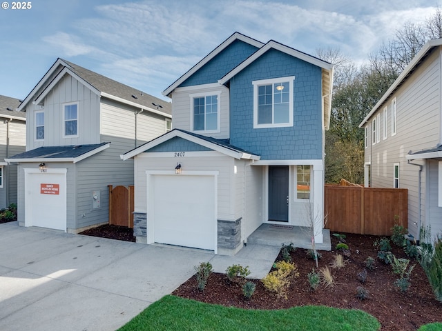 view of front of home with concrete driveway, an attached garage, board and batten siding, fence, and stone siding