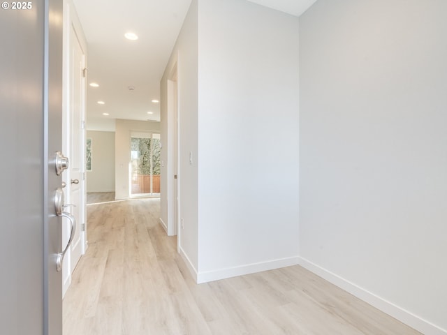 hallway featuring recessed lighting, baseboards, and light wood finished floors