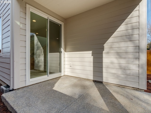 view of exterior entry with a patio area