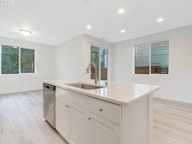 kitchen with light countertops, dishwasher, light wood-style flooring, and a sink