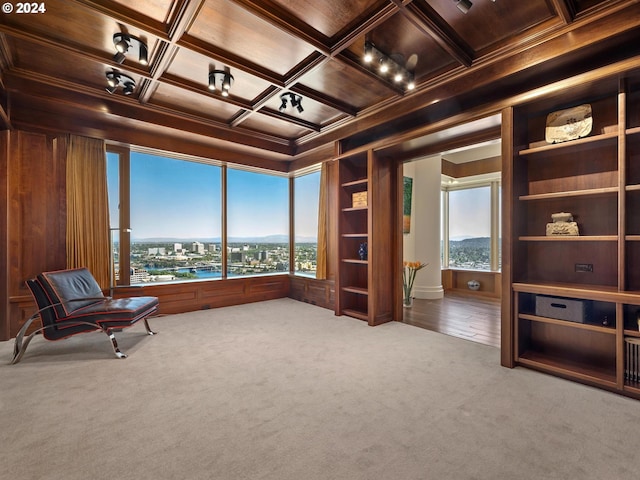 unfurnished room with coffered ceiling, carpet flooring, wooden walls, and wooden ceiling