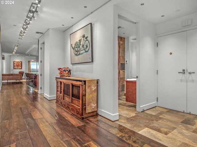 hall with hardwood / wood-style floors and track lighting