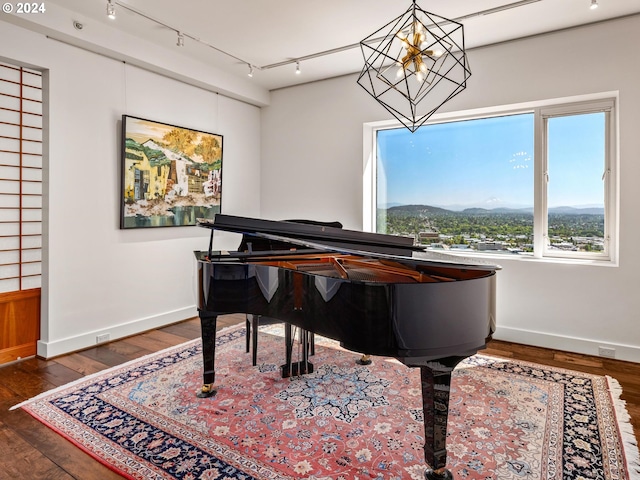 living area featuring a notable chandelier, baseboards, and wood finished floors