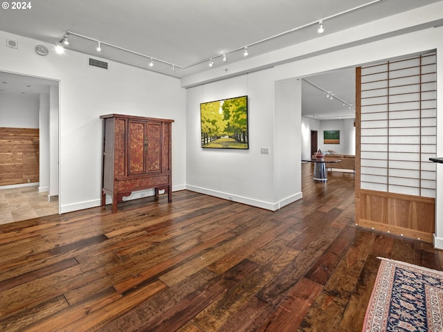 spare room with visible vents, track lighting, baseboards, and wood-type flooring