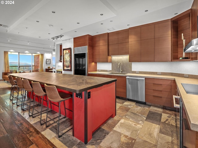 kitchen with built in refrigerator, a large island, a sink, stainless steel dishwasher, and black electric cooktop