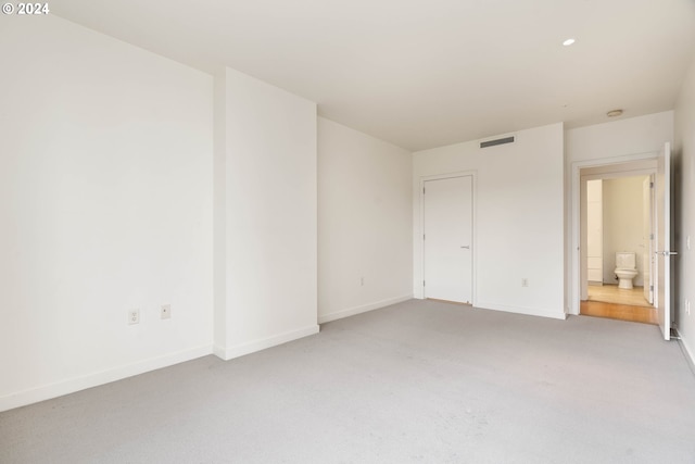 unfurnished bedroom featuring baseboards, visible vents, and light colored carpet