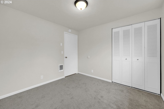 unfurnished bedroom with carpet flooring and a closet