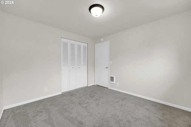 unfurnished bedroom featuring carpet floors and a closet