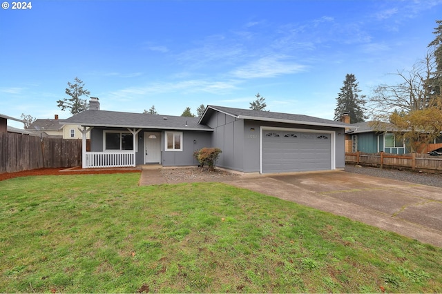 ranch-style house with covered porch, a garage, and a front yard