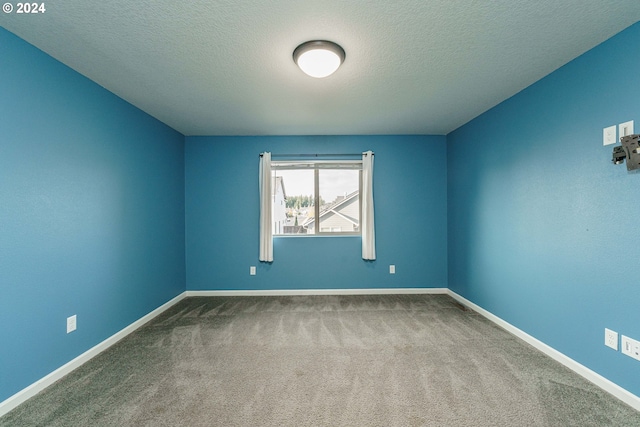 unfurnished room with a textured ceiling and carpet floors