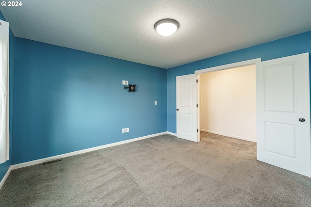 unfurnished bedroom featuring carpet and a textured ceiling