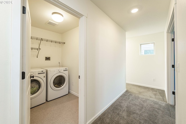 clothes washing area with light carpet and washing machine and clothes dryer