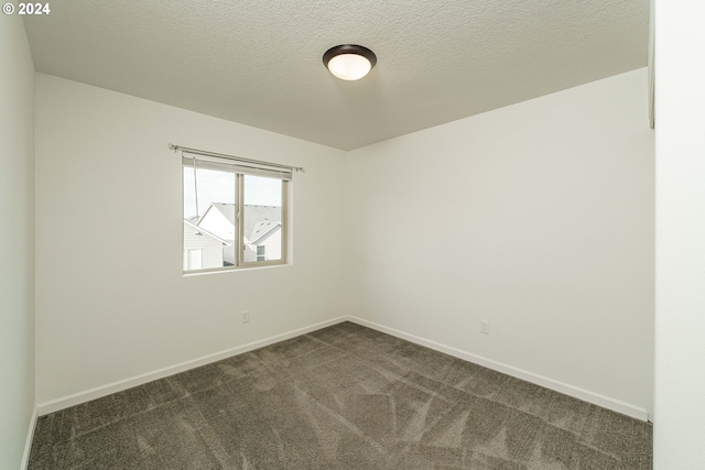 carpeted empty room featuring a textured ceiling