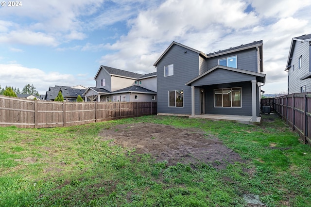 rear view of property featuring a yard and central AC