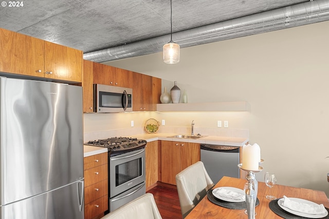 kitchen featuring pendant lighting, dark hardwood / wood-style floors, sink, and stainless steel appliances