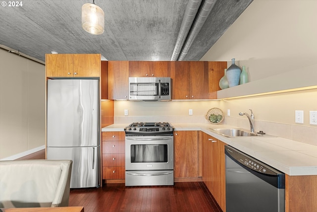 kitchen featuring pendant lighting, stainless steel appliances, dark hardwood / wood-style floors, and sink