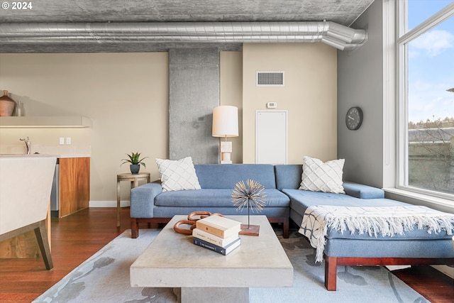 living room with plenty of natural light and dark wood-type flooring