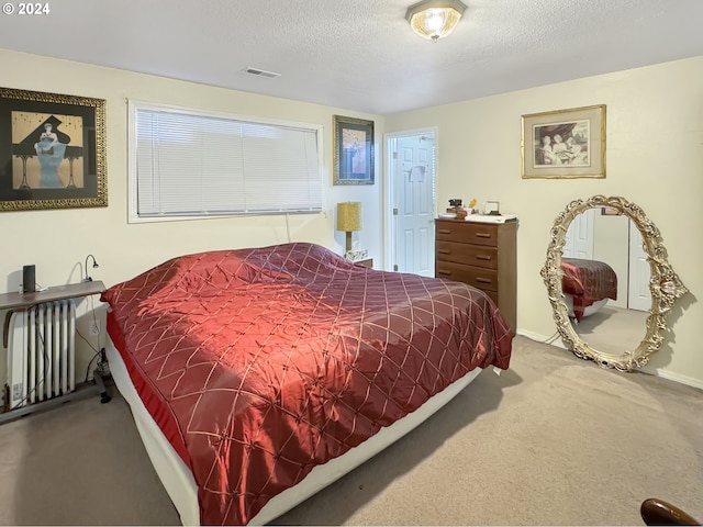 bedroom with a textured ceiling, radiator, and carpet floors