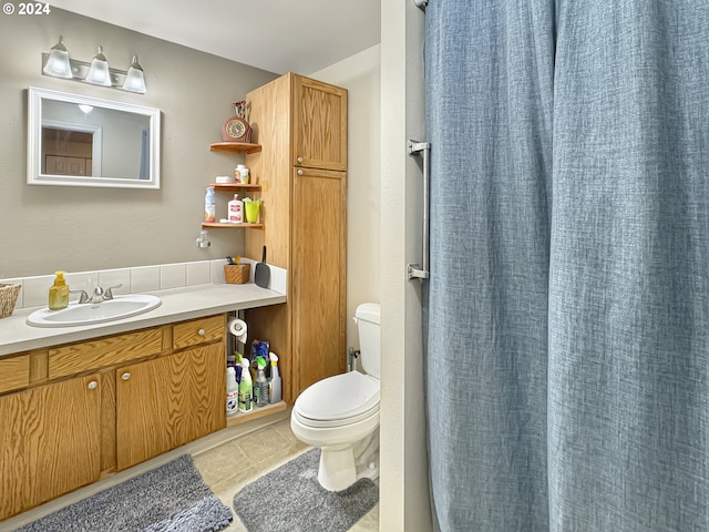 bathroom with tile patterned flooring, toilet, walk in shower, and vanity