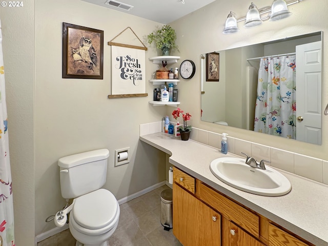 bathroom with tile patterned flooring, vanity, toilet, and walk in shower