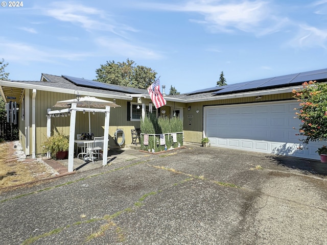 view of front of property featuring a garage and solar panels