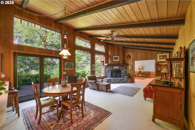 dining area featuring ceiling fan, carpet floors, and wooden walls