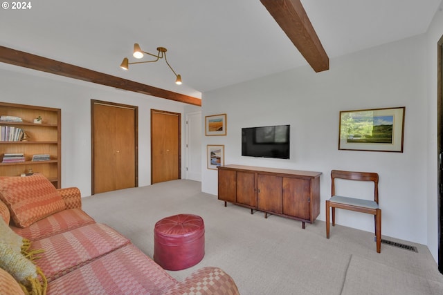 living room with beamed ceiling, light colored carpet, and an inviting chandelier