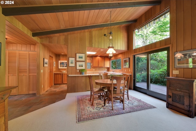 dining area with wooden walls, light colored carpet, lofted ceiling with beams, and wooden ceiling