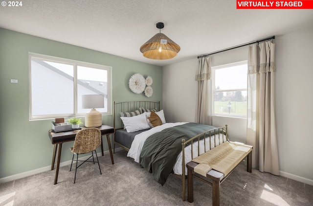 carpeted bedroom with multiple windows and a textured ceiling