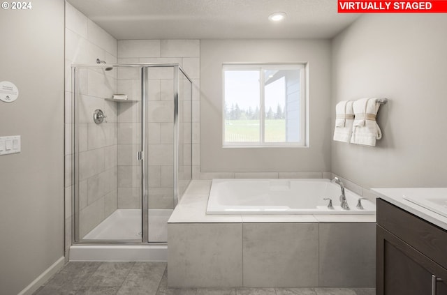 bathroom with vanity, independent shower and bath, and a textured ceiling