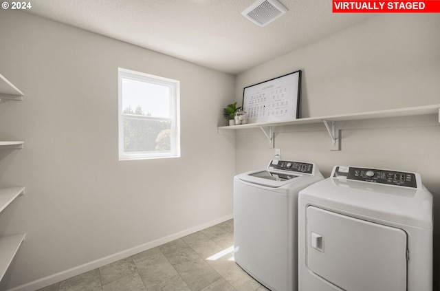 washroom with washer and dryer and a textured ceiling