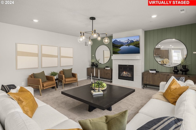 living room with light carpet, an inviting chandelier, and a fireplace