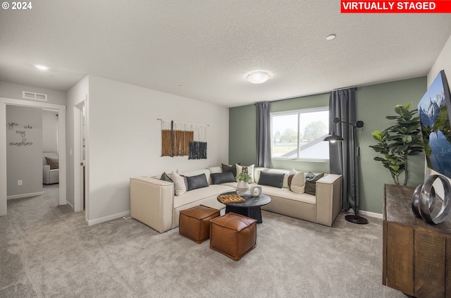 living room featuring a textured ceiling and light colored carpet