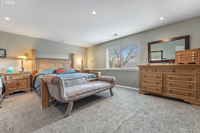 bedroom with light colored carpet and a textured ceiling