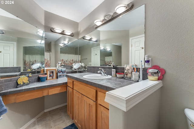 bathroom with decorative backsplash, tile patterned flooring, and vanity