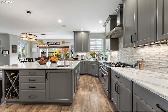 kitchen featuring decorative light fixtures, high end stove, gray cabinets, and dark hardwood / wood-style floors