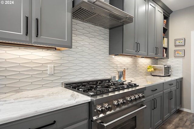 kitchen featuring gray cabinetry, dark hardwood / wood-style floors, high end stove, backsplash, and custom range hood