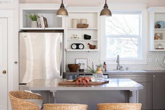 kitchen featuring hanging light fixtures, a breakfast bar area, and stainless steel fridge