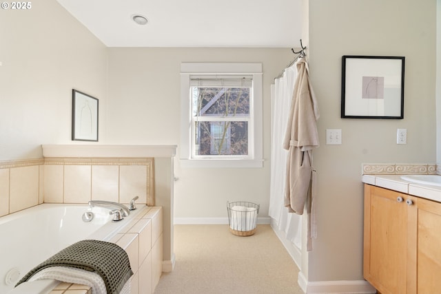 bathroom featuring vanity and tiled bath