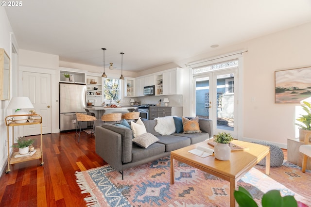 living room with dark wood-type flooring, french doors, and a healthy amount of sunlight