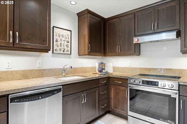 kitchen with dark brown cabinetry, under cabinet range hood, stainless steel appliances, and a sink