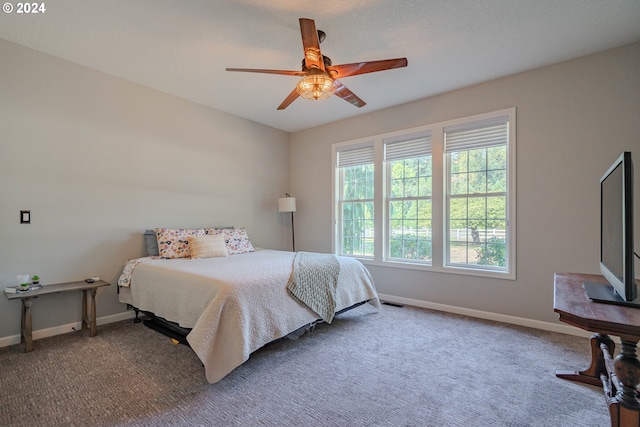 carpeted bedroom with ceiling fan and baseboards