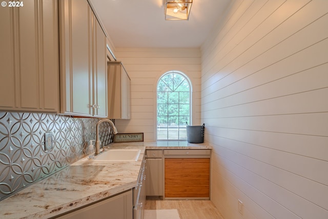 kitchen featuring light wood-style flooring, backsplash, and a sink