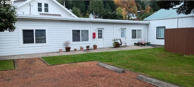 rear view of house featuring a patio area and a yard