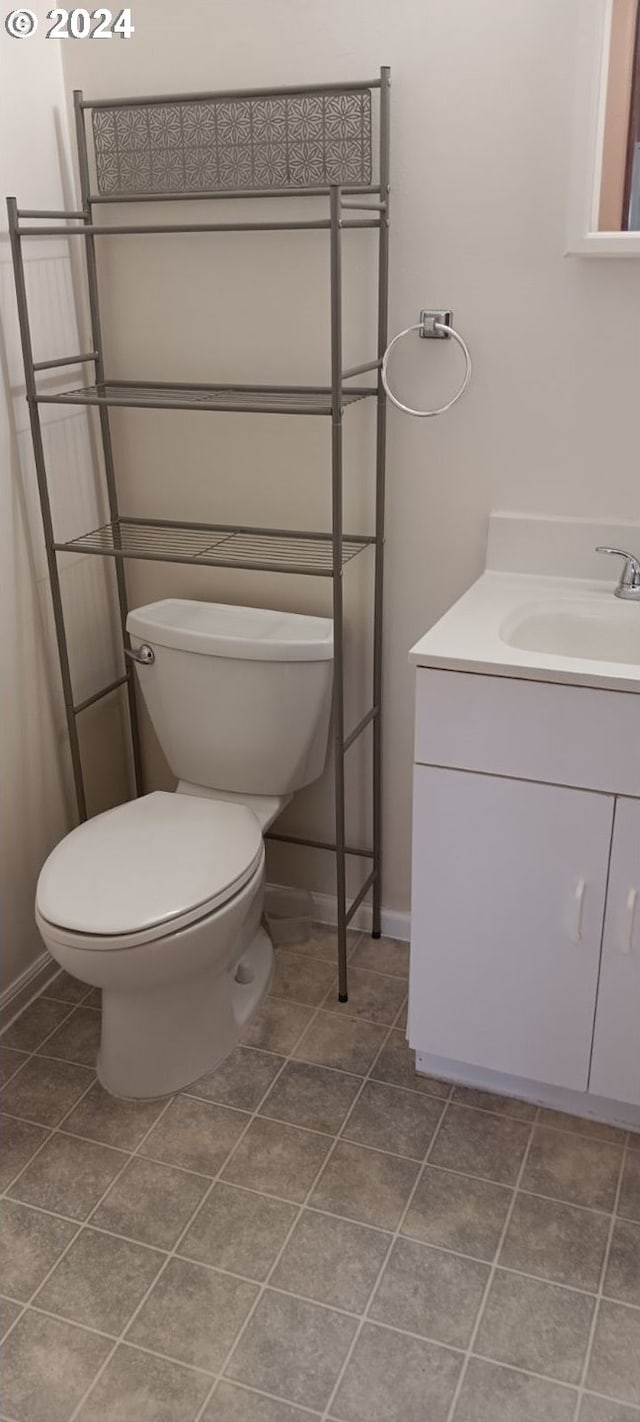 bathroom featuring baseboards, vanity, toilet, and tile patterned floors