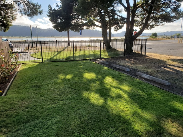 view of yard with a water view and fence